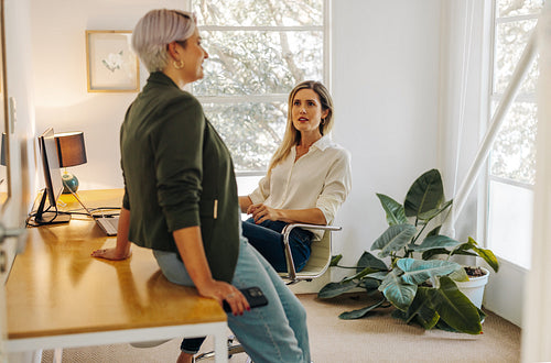 Two young businesswomen having a discussion in an office