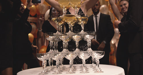 Woman filling champagne in glasses pyramid at party