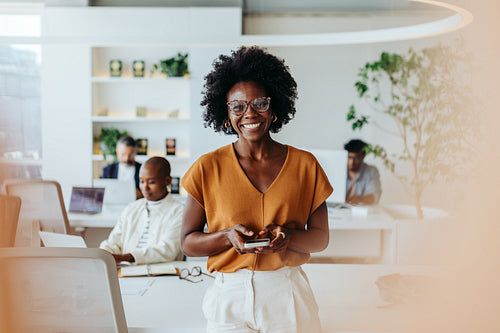 Portrait of a mature businesswoman holding a mobile phone in a creative office