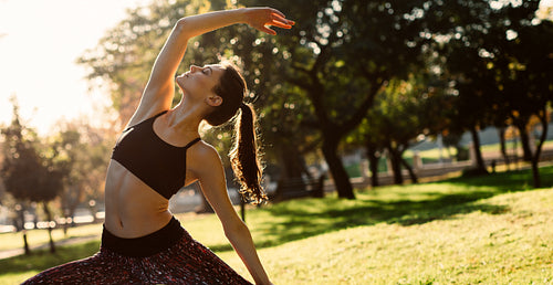 Healthy woman doing yoga stretches at the park