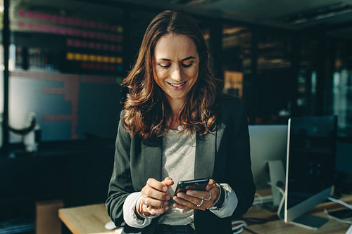 Woman entrepreneur using a phone in office