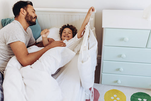 Father and son on bed waking up