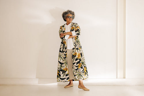 Senior businesswoman standing against an office wall