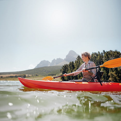 Senior woman canoeing on a summer day