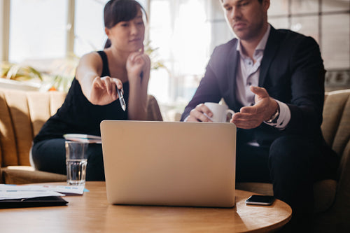 Woman presenting business idea on laptop to businessman