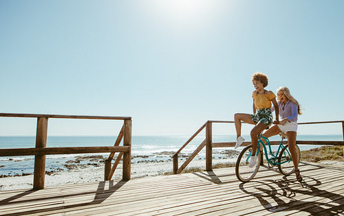 Joyful friends riding a bicycle 