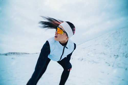Outdoor running shows a woman training alone through winter snow