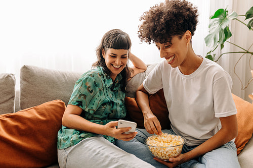 Happy lesbian couple video calling their friends