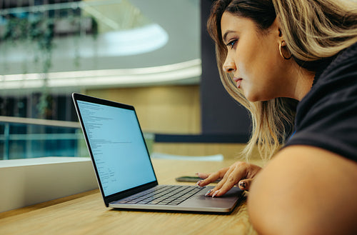 Focused businesswoman working on laptop in modern office