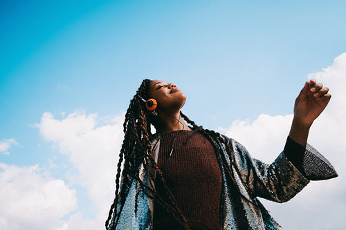 Dancing woman moves to music with headphones outdoors