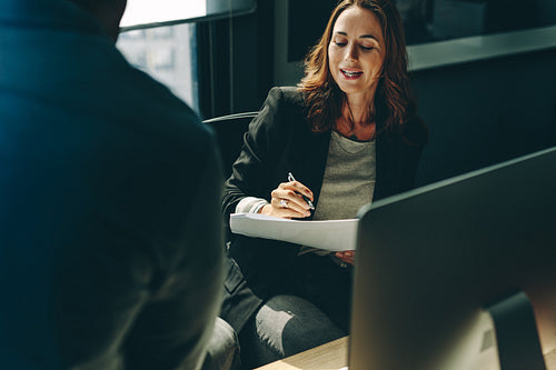 Business colleagues discussing over a report in office