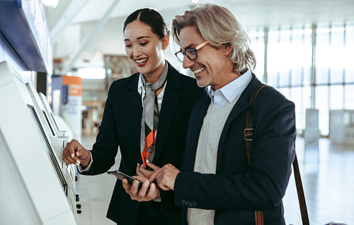 Ground attendant helping business traveler in self check in