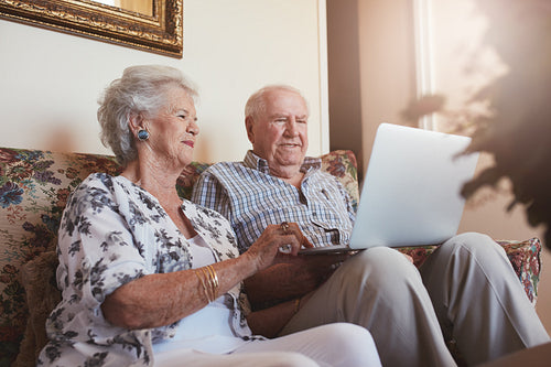 Elderly couple using laptop at home
