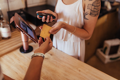 Woman entrepreneur accepting payment by card at the billing counter