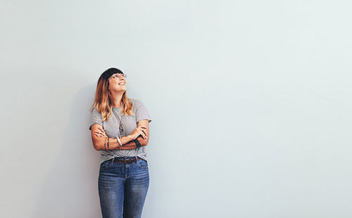 Woman standing against wall looking away