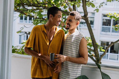 Happy couple enjoying a morning together on their apartment balcony