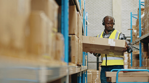 Male warehouse worker using a headset to pick orders and communicate with a warehouse management system