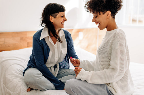 Excited lesbian woman holding a positive pregnancy test