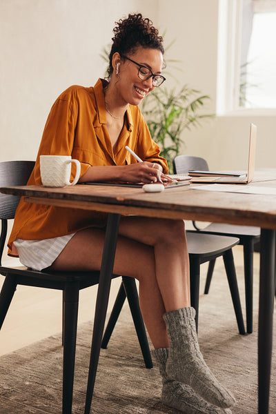 Woman working on a digital tablet at home