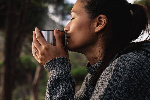 Young asian woman having coffee outdoors