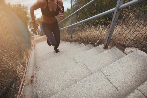 Fitness young woman running up stairs