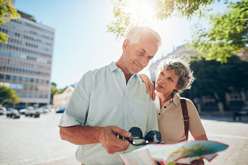 Senior couple using road map in a foreign city