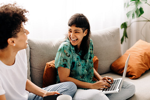Female couple laughing together at home