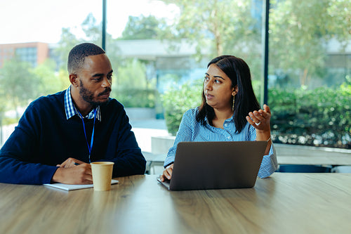 Colleagues discussing accounting strategies in office environment