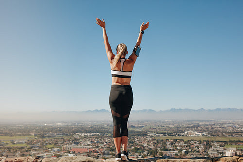 Rear view of a fitness woman standing on a hill