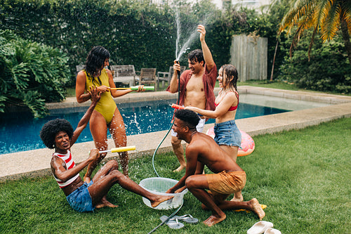 Pool party with water fight in backyard