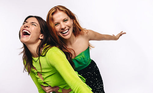 Friends laughing and leaning in studio pose