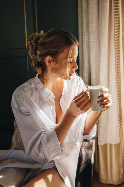 Carefree woman having coffee in her hotel room