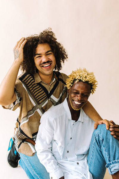 Ethnic gay couple smiling cheerfully