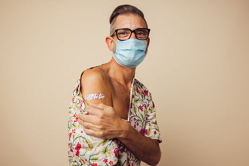 Mature man shown arm after getting corona virus vaccine