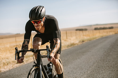 Cyclist on road bike through countryside road