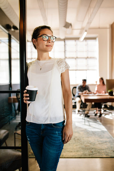 Beautiful woman in office doorway with coffee