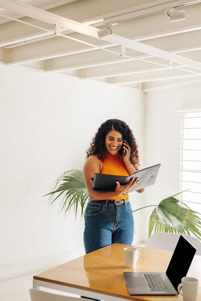 Happy young businesswoman speaking on the phone in an office