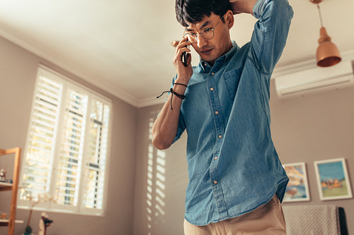 Man looking stressed while answering phone call