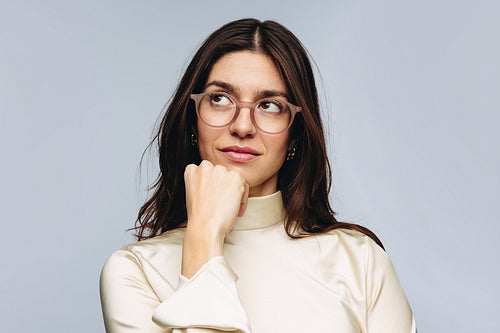 Woman thinking with hand on chin