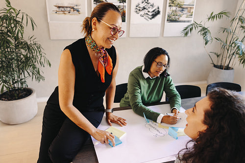 Collaborative architectural planning meeting with team members discussing ideas