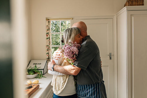 Senior couple embracing standing at home