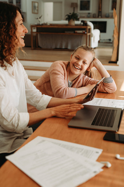 Woman giving attention to her daughter while working at home