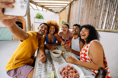Group of friends taking a selfie during a summer gathering outdoors