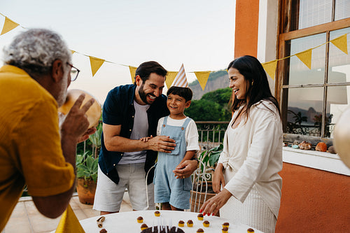 Family celebrating a birthday party outdoors on a sunny day