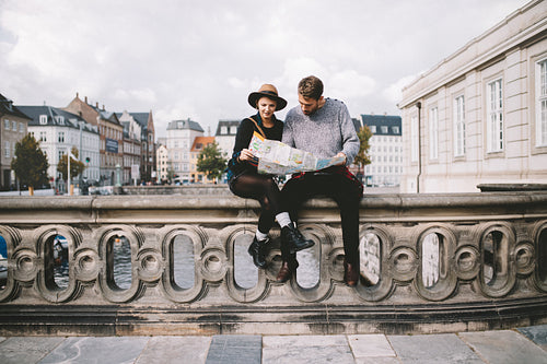 Young tourist couple looking at a navigational map.