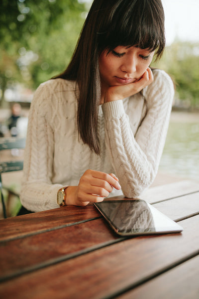 Young woman using digital tablet at outdoor cafe.