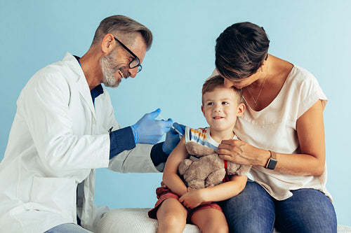 Doctor giving vaccine to a boy