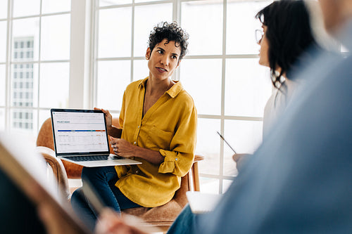 Business woman discussing a project report with her colleagues