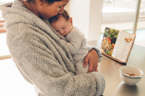 Newborn baby boy sleeping in his mother's hands