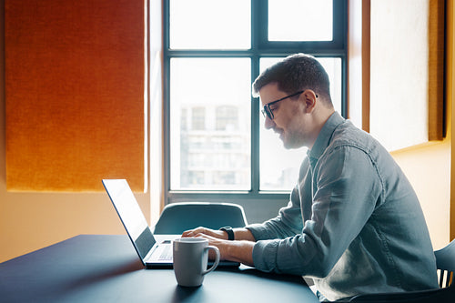 Man working on laptop in a bright modern office environment